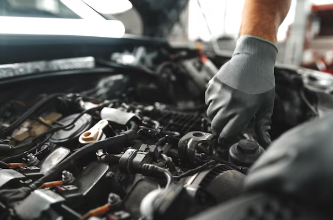 Technician inspecting vehicle engine during service