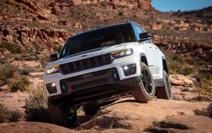Jeep Grand Cherokee driving off-road over rocky desert trail