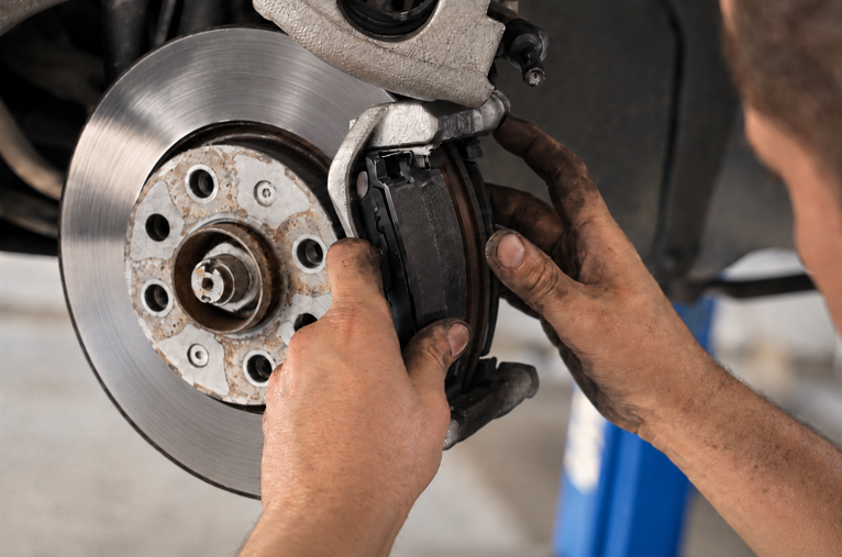 Technician installing brake pad during vehicle brake service
